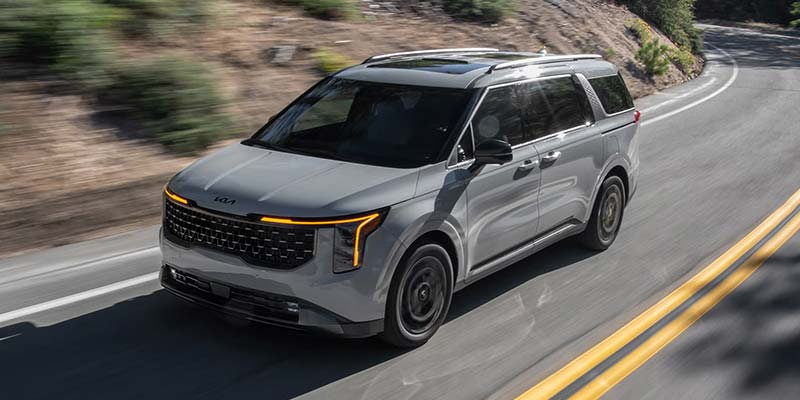 2026 Kia Carnival hybrid driving on a winding road