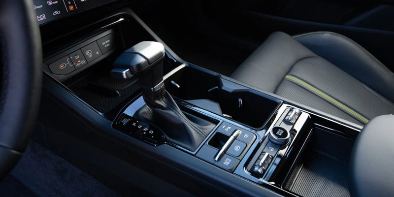 Car center console with gear shifter and controls.