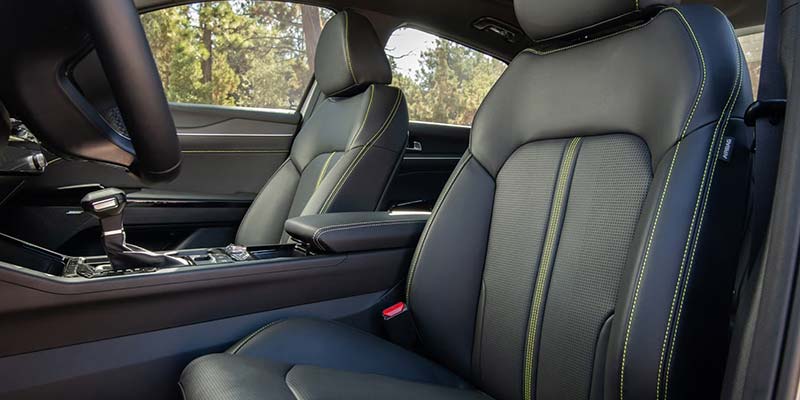 Front interior view of a car showing the driver and passenger seats with contrast stitching.