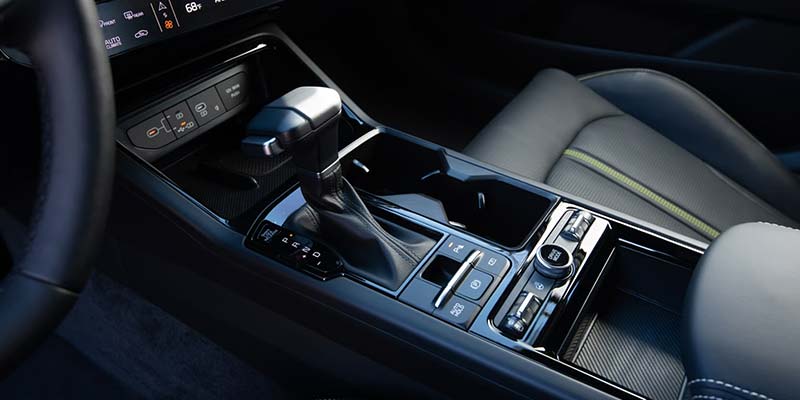 Close-up of a car’s center console with gear shifter and control buttons.