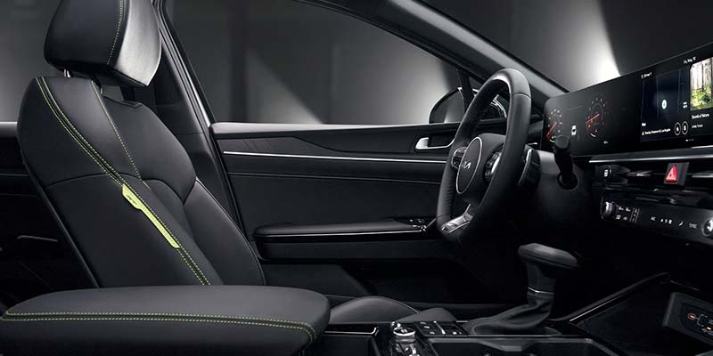  Interior view of a modern car showing the front seat, steering wheel, and digital dashboard.